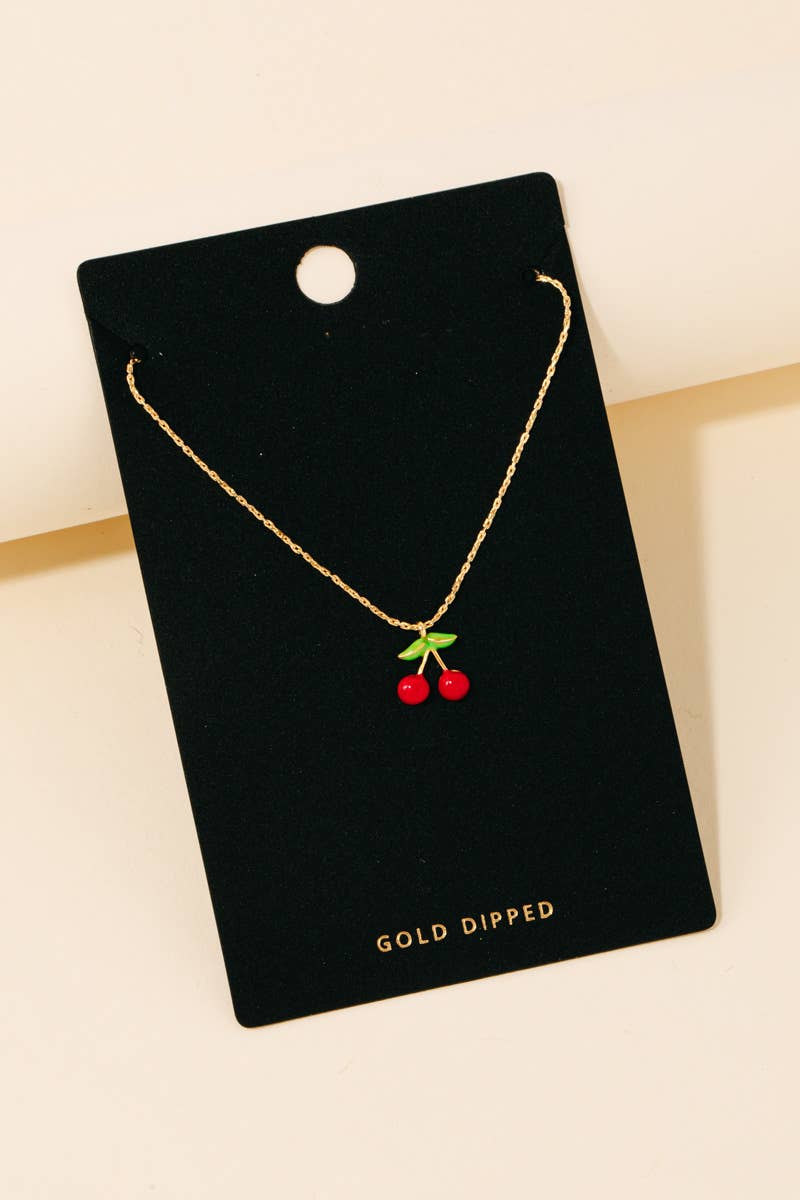 Gold Dipped Epoxy Cherry Pendant Necklace displayed against a black card, showcasing its vibrant red cherries and green leaves on a delicate gold chain.