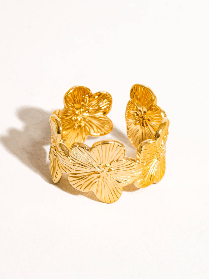 Side angle of a gold hibiscus-inspired ring showcasing its delicate floral pattern.