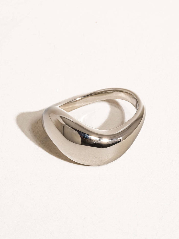 Side view of a silver statement ring with a bold, sculptural wave design, perfect for adding a modern touch to any outfit.