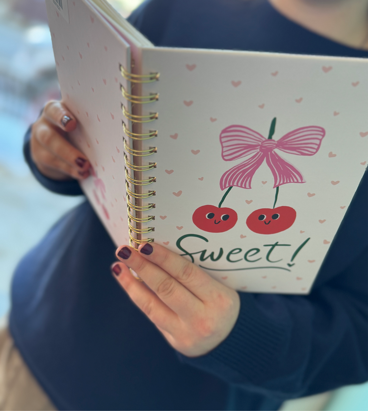 Girl holding open notebook with cherry front 