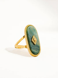 Angled view of a gold ring featuring a green marbled oval stone, beaded border, and a unique geometric detail for a sophisticated look