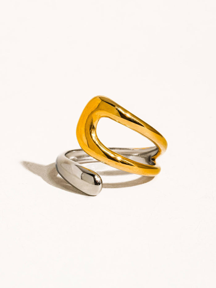 A contemporary two-tone open band ring with a dynamic twist design, blending shiny silver and gold tones for a versatile and sophisticated accessory.