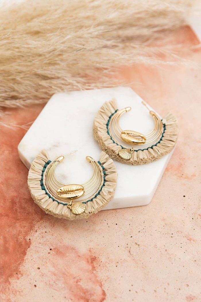 Seashell Glow Golden Raffia Hoop Earrings on display stand