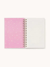 Inside view of the notebook showing lined pages and a pink heart-patterned cover.