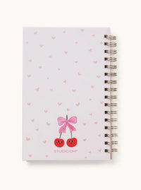 Back cover of the cherry-themed notebook with soft pink heart details and spiral binding.